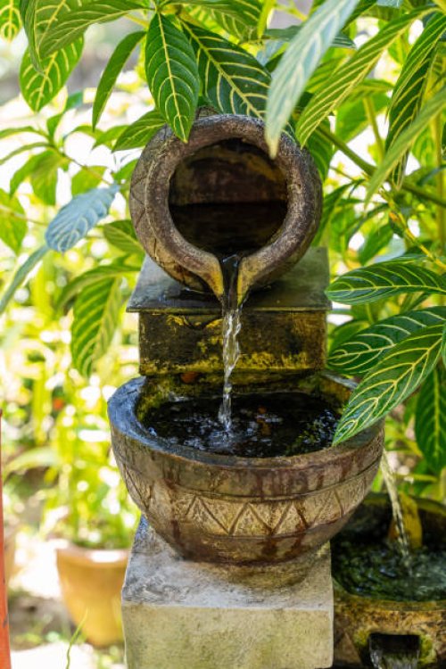 small stone water fountain in garden with plant - garden decoration stock pictures, royalty-free photos & images