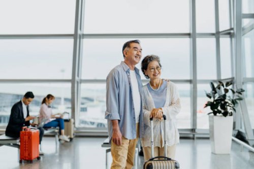 smiling asian senior couple tourists in airport - travel stock pictures, royalty-free photos & images