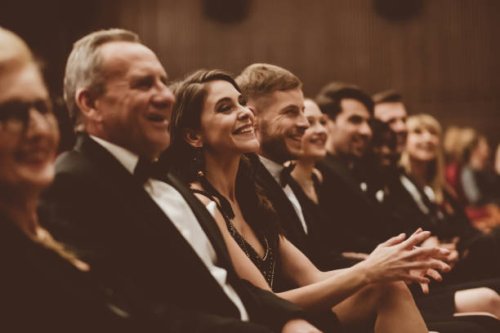 smiling audience sitting in the theater - concert stock pictures, royalty-free photos & images