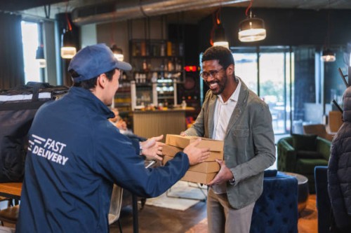 smiling black male customer receiving a food delivery - junk food stock pictures, royalty-free photos & images