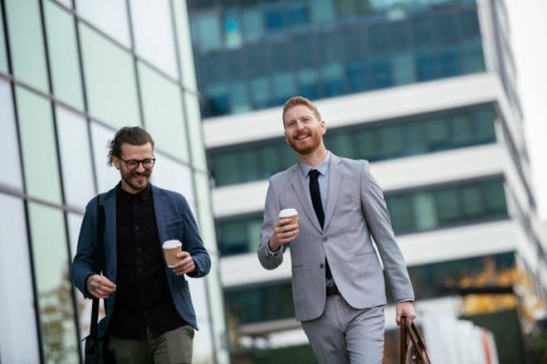 smiling businessman walking with coffee cups stock photo - junk food stock pictures, royalty-free photos & images