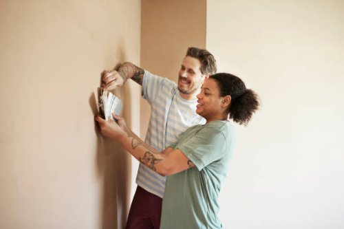 smiling couple choosing paint color for home - home decoration stock pictures, royalty-free photos & images