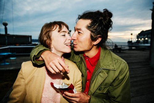 smiling couple sharing piece of chocolate while on date - food stock pictures, royalty-free photos & images