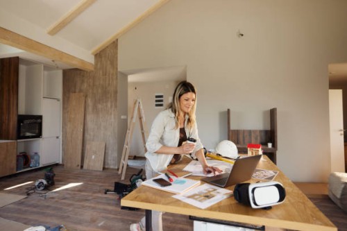 smiling female architect working on laptop at construction site. - home decoration stock pictures, royalty-free photos & images