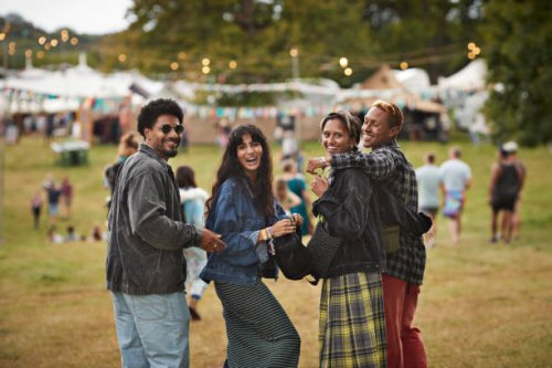 smiling friends with arms around walking at park - concert stock pictures, royalty-free photos & images