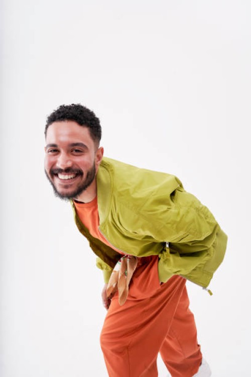 smiling man bending against white background - fashion stock pictures, royalty-free photos & images