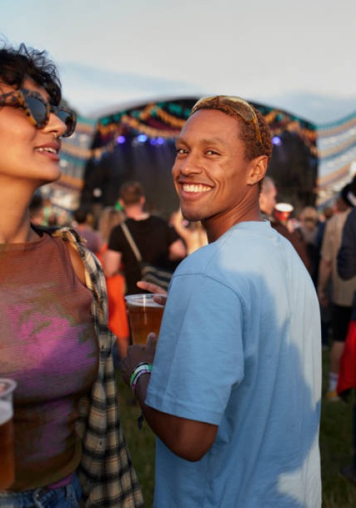 smiling man with woman enjoying music festival - concert stock pictures, royalty-free photos & images