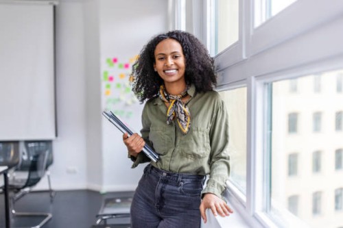 smiling portrait of a beautiful woman standing in office - fashion stock pictures, royalty-free photos & images
