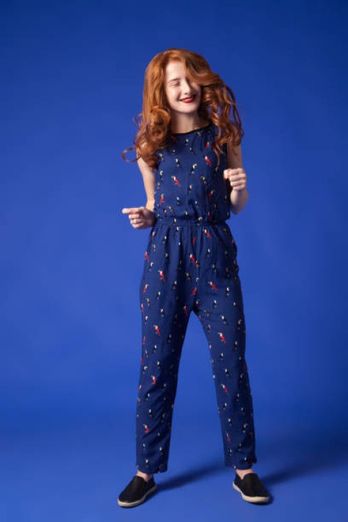 smiling redhead woman in combo suit - fashion stock-fotos und bilder