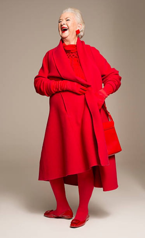 smiling senior woman wearing red coat - fashion stock pictures, royalty-free photos & images