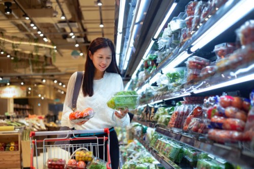 smiling woman at supermarket - food stockfoto's en -beelden