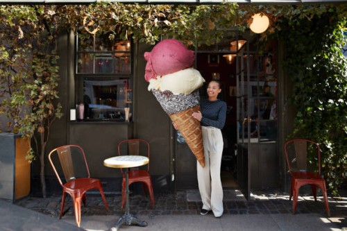 smiling woman carrying large ice cream cone at sidewalk cafe - food stock pictures, royalty-free photos & images