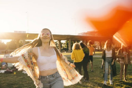 smiling woman dancing with friends in background at event on sunny day - concert stock pictures, royalty-free photos & images