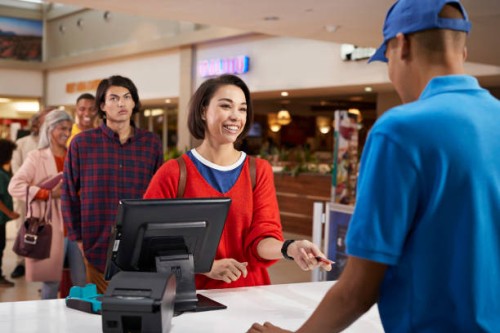 smiling woman paying for movie tickets - junk food stock pictures, royalty-free photos & images