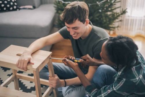 smiling young couple working together to restore some chair - home decoration stock pictures, royalty-free photos & images