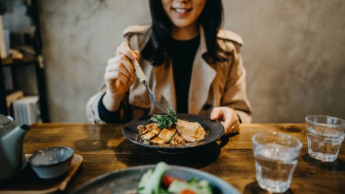 smiling young woman enjoying dinner date with friends in a restaurant - food stock pictures, royalty-free photos & images