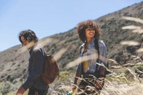 smiling young woman hiking with boyfriend on sunny day - travel stock pictures, royalty-free photos & images