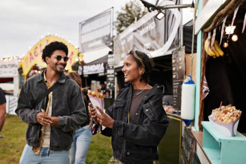 smiling young woman holding dessert by friend - junk food stock pictures, royalty-free photos & images