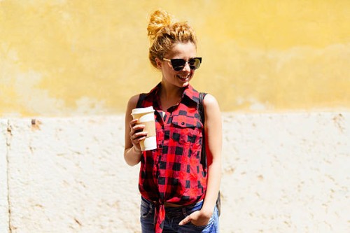 smiling young woman with coffee to go - junk food stock pictures, royalty-free photos & images