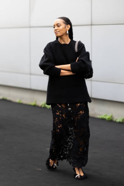 Solange Knowles is seen wearing hoop silver earrings, black fur sandals embroidered with rhinestones, a black long sweater, a black long lace skirt...