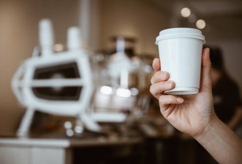 someone hand holding a paper cup of hot coffee in coffee shop. - junk food stock pictures, royalty-free photos & images