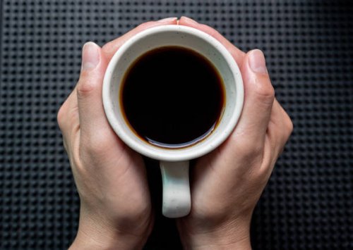 someone hands holding a mug of black coffee before drinking. - coffee stock pictures, royalty-free photos & images