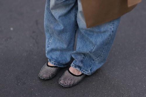 Sonia Lyson is seen wearing a beige long coat from Sezane, wide jeans from Zara and rhinestones-covered black net ballet flats from Zara on September...