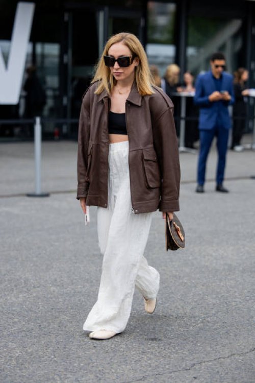Sonia Lyson wears shoes Tabitha Simmons, white pants Zara, brown leather jacket Ducie London, Louis Vuitton round bag, YSL sunglasses outside Lueder...