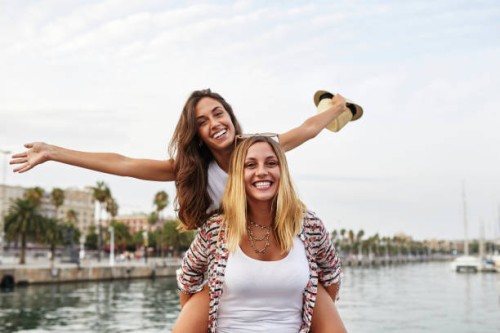 spain, barcelona, young woman giving her friend a piggyback ride - fashion stock pictures, royalty-free photos & images