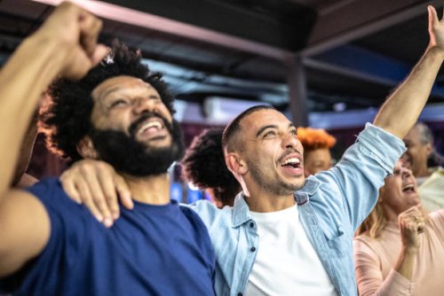 sports fans watching a match and celebrating at a bar - concert stock pictures, royalty-free photos & images