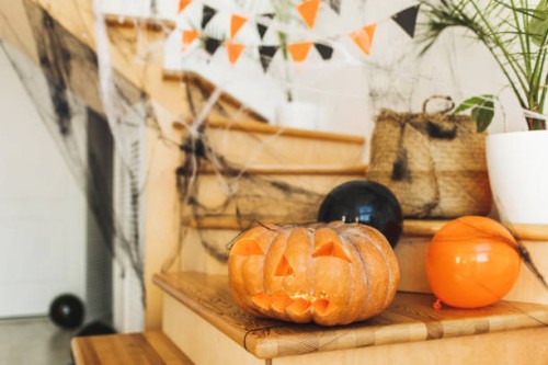 staircase decorated for halloween with pumpkin lantern, black and orange balloons, cobweb and flag garland - home decoration stockfoto's en -beelden