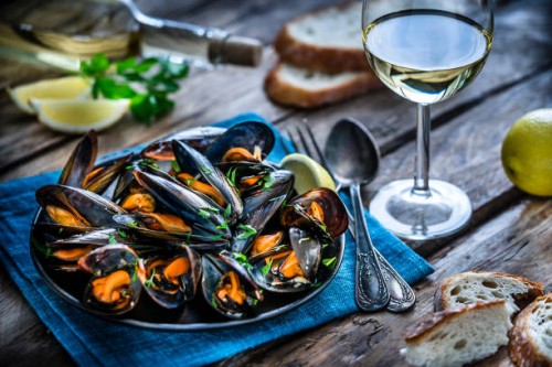 steamed mussels and white wine on rustic wooden table - food stock pictures, royalty-free photos & images