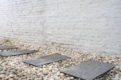 stepping stones and white brick wall - garden decoration stock pictures, royalty-free photos & images