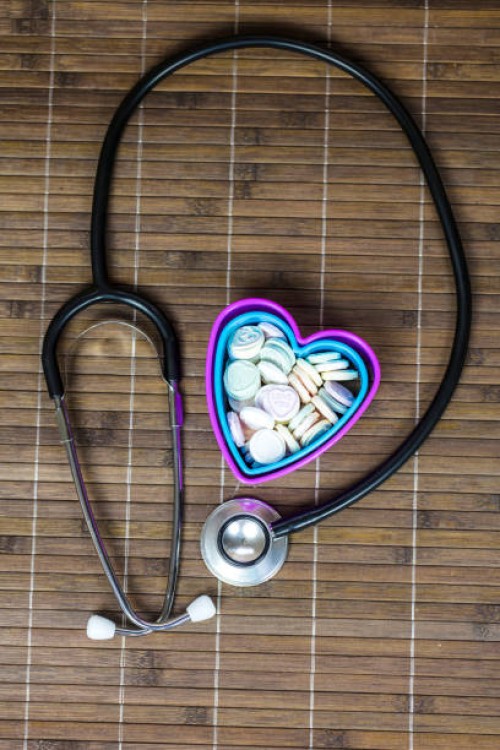 stethoscope and multi colored heart shape candy with text in heart shape container - junk food stock pictures, royalty-free photos & images