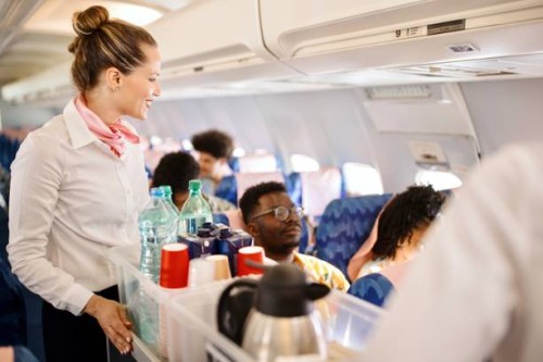 stewardesses serving food and drinks to customer on the airplane during flight - food stock pictures, royalty-free photos & images