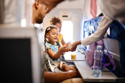 stewardesses serving food and drinks to family on the airplane during flight - food stock pictures, royalty-free photos & images