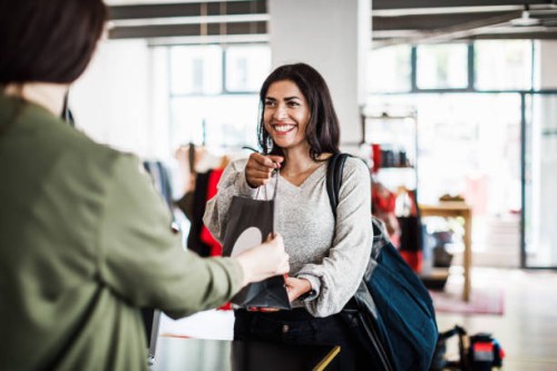 store clerk handing customer purchased items - fashion stock pictures, royalty-free photos & images