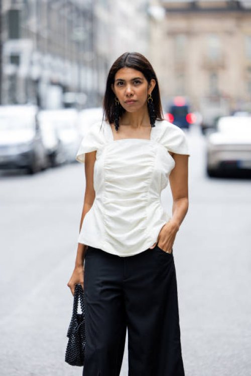 Storm Westphal-Knieling wears white blouse, black wide leg pants, bag outside William Fan during the Berlin Fashion Week SS25 on July 03, 2024 in...