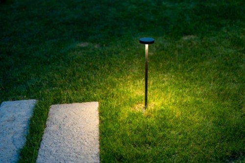 street lamps on the lawn illuminate the road. - garden decoration stock pictures, royalty-free photos & images