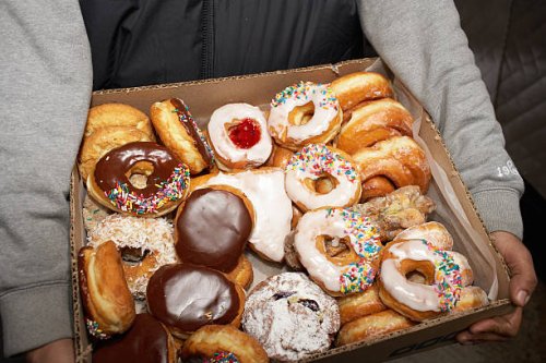 street vendor carrying box of doughnuts, mid section, elevated view - junk food stock pictures, royalty-free photos & images