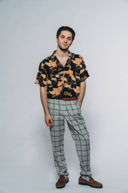 studio portrait of a young adult man against a gray background - fashion stock pictures, royalty-free photos & images