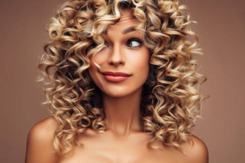 studio portrait of attractive young woman with voluminous curly hairstyle - hairstyle stock pictures, royalty-free photos & images