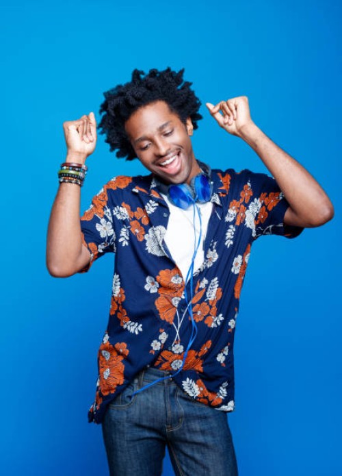 studio portrait of dancing young man in hawaiian shirt - fashion stock pictures, royalty-free photos & images
