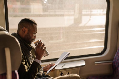 stylish businessman with reusable cup and documents in a train - junk food stock pictures, royalty-free photos & images