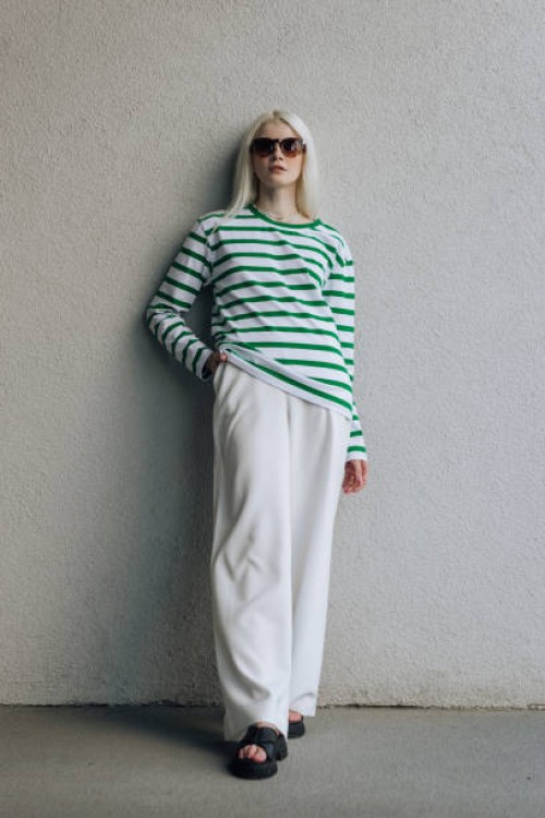 stylish fashion model in sunglasses against a white wall posing in modern trendy clothes - fashion stock pictures, royalty-free photos & images