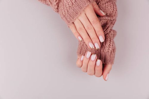 stylish pastel pink beige nails holding knitted wool material on hell background - nails art stock pictures, royalty-free photos & images