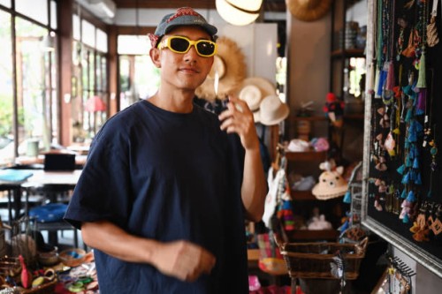 stylish thai man trying on sunglasses in a boutique - fashion stock pictures, royalty-free photos & images