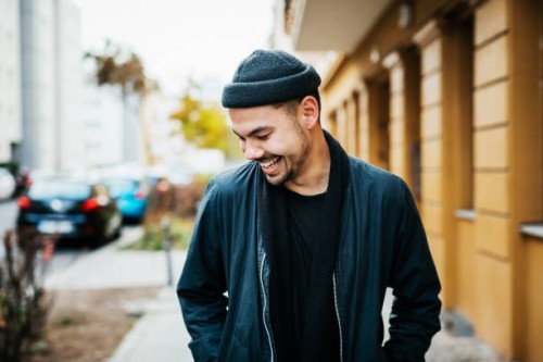 stylish young man laughing in city street - fashion stock pictures, royalty-free photos & images