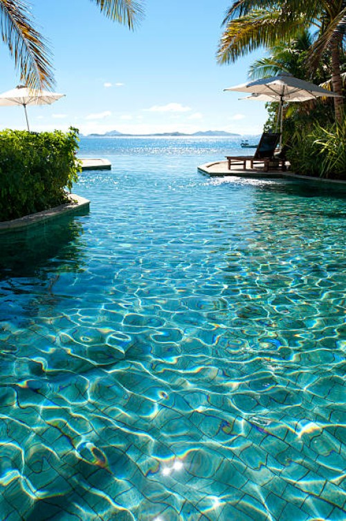 sun lounges beside a pool with ocean - home decoration stock pictures, royalty-free photos & images