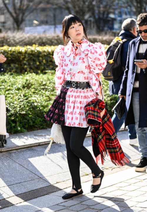 Susie Lau is seen wearing a red and white Stella McCartney dress, black and silver belt, black leggings and plaid scarf outside the Stella McCartney...
